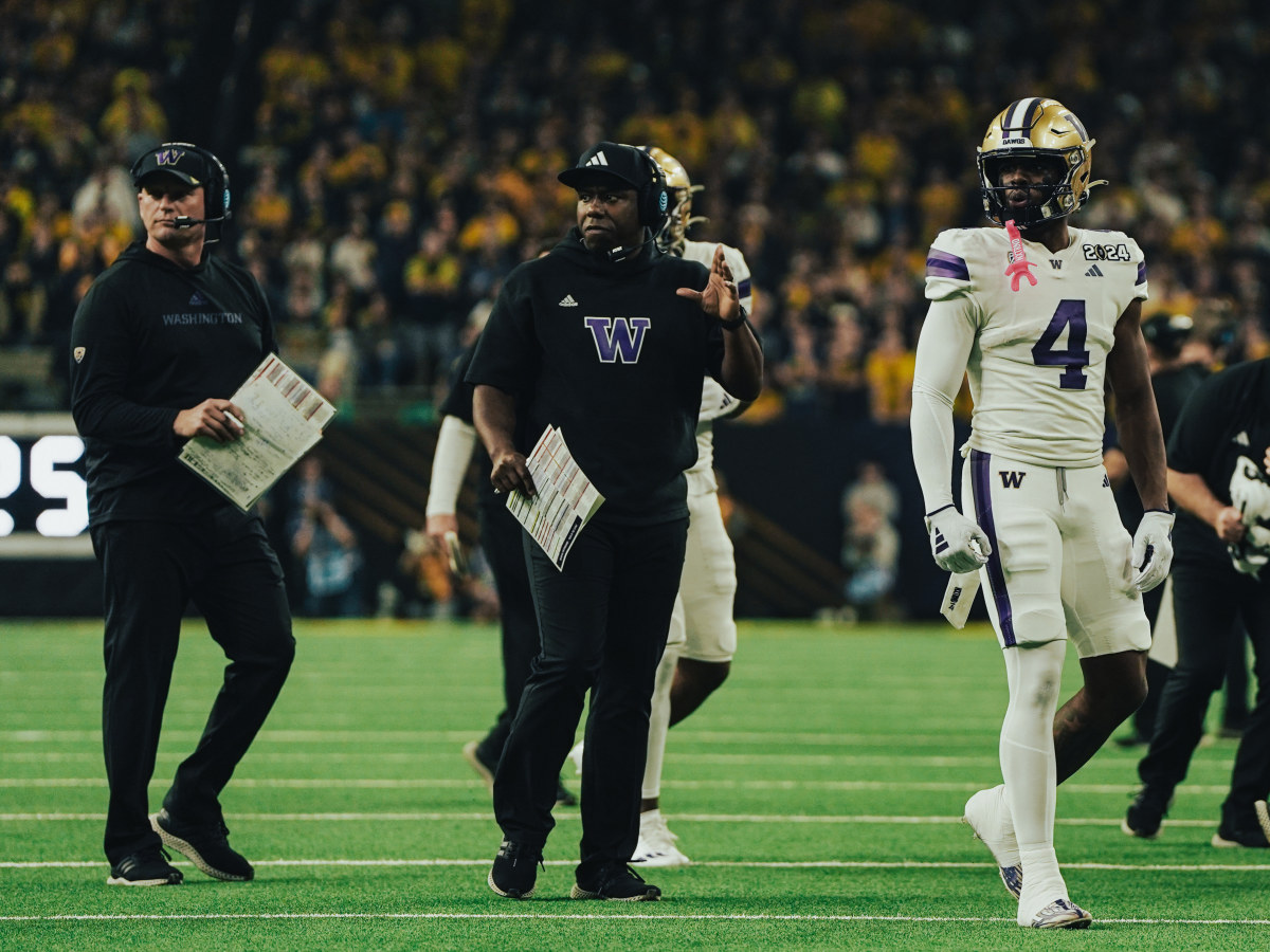 Germie Bernard stands near the Husky sideline with Kalen DeBoer and JaMarcus Shephard in the CFP title game.