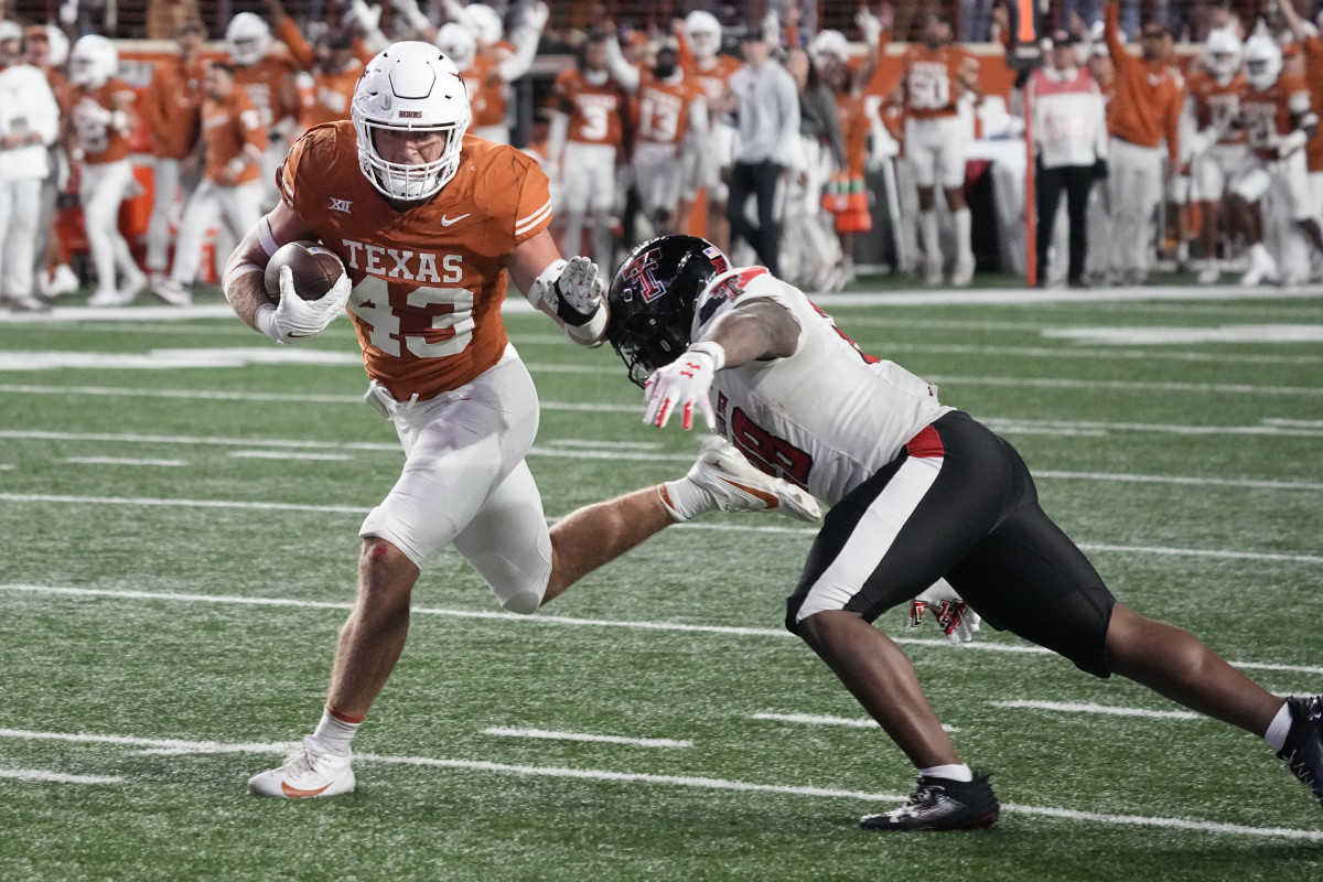 Nov 24, 2023; Austin, Texas, USA; Texas Longhorns linebacker Jett Bush (43) runs in to the end zone while defended by Texas Tech Red Raiders running back Tahj Brooks (28) during the second half at Darrell K Royal-Texas Memorial Stadium. Mandatory Credit: Scott Wachter-USA TODAY Sports