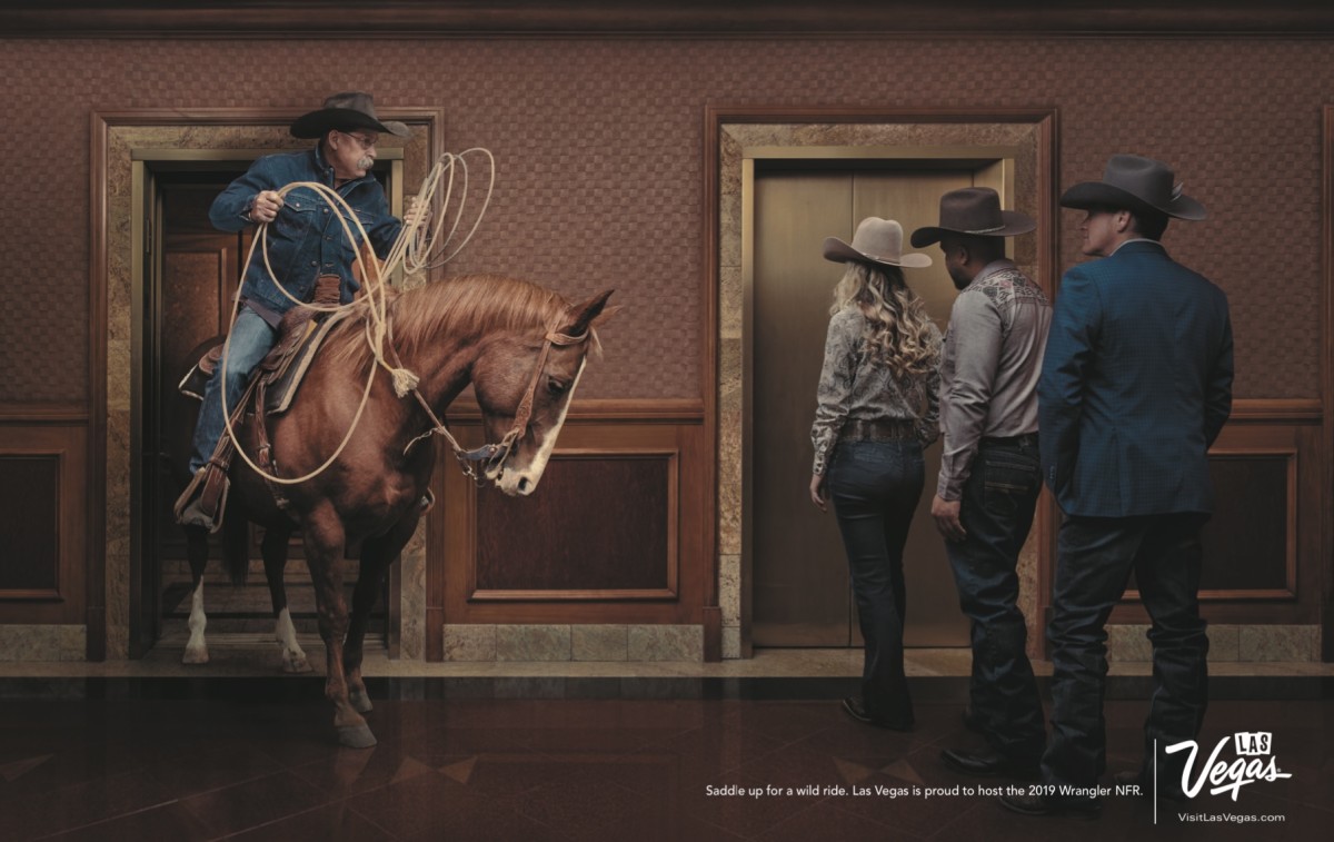 Lloyd Faria walks his horse through an elevator at the South Point Hotel in the early morning hours with Ryan Growney standing to his left, next to a couple of hotel guests.