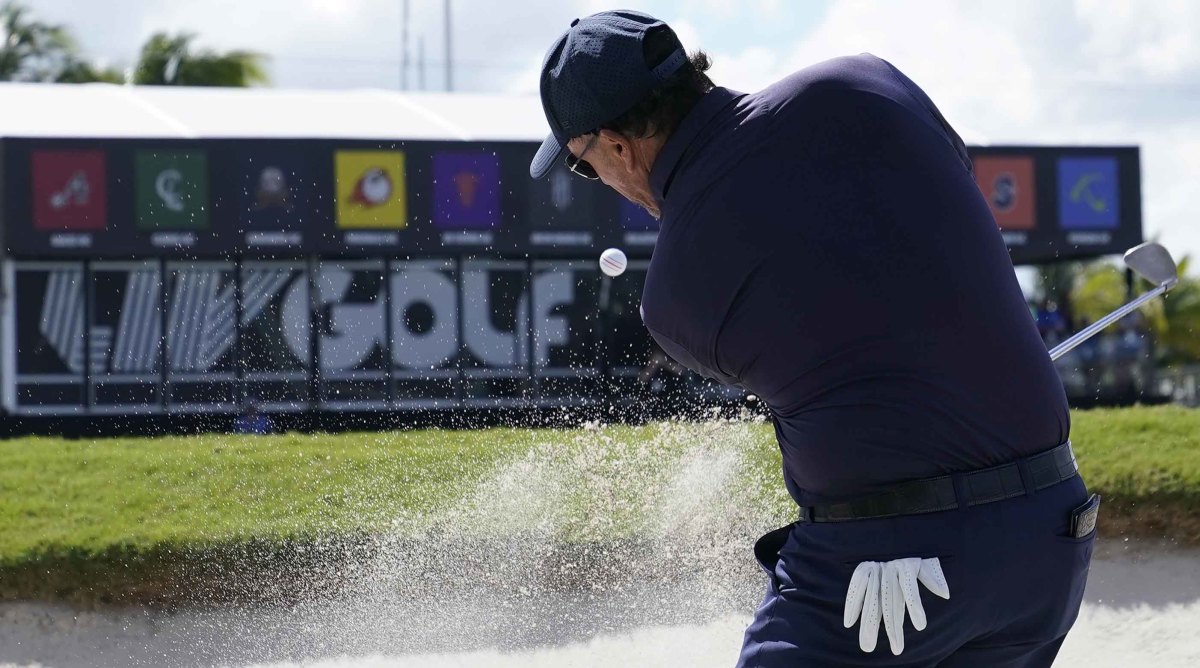 Phil Mickelson is shown hitting out of a bunker at the 2022 LIV Golf Invitational Miami Team Championship.