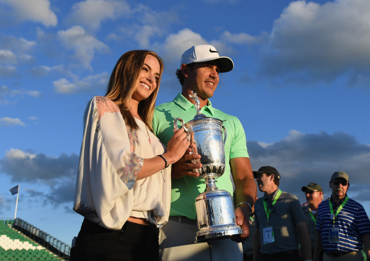 Brooks Koepka of the United States poses with the winner's trophy with Jena Sims after his victory at the 2017 U.S. Open at Erin Hills on June 18, 2017 in Hartford, Wisconsin.