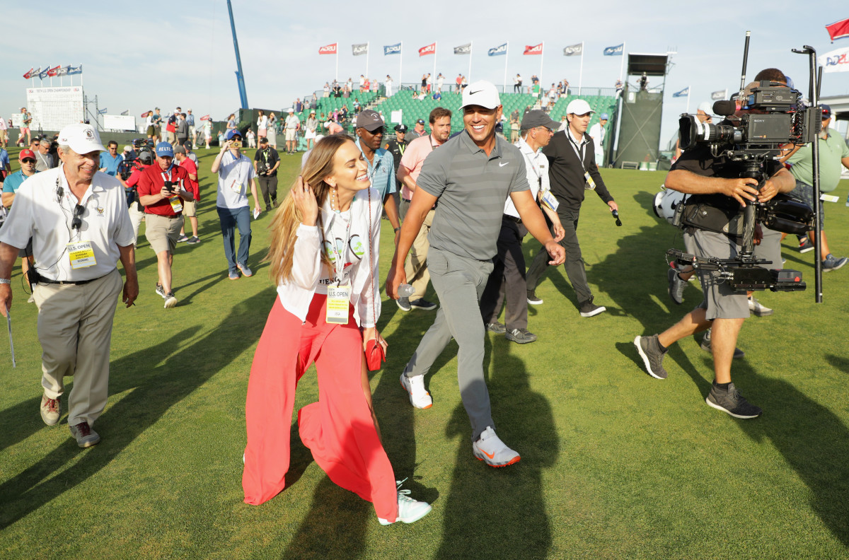 Brooks Koepka of the United States walks off on the 18th green with girlfriend Jena Sims during the final round of the 2018 U.S. Open at Shinnecock Hills Golf Club on June 17, 2018 in Southampton, New York.