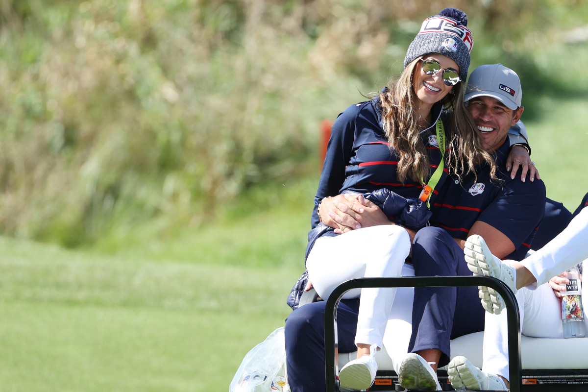 Brooks Koepka of team United States and wife Jena Sims ride off on a cart during Friday Morning Foursome Matches of the 43rd Ryder Cup at Whistling Straits on September 24, 2021 in Kohler, Wisconsin.