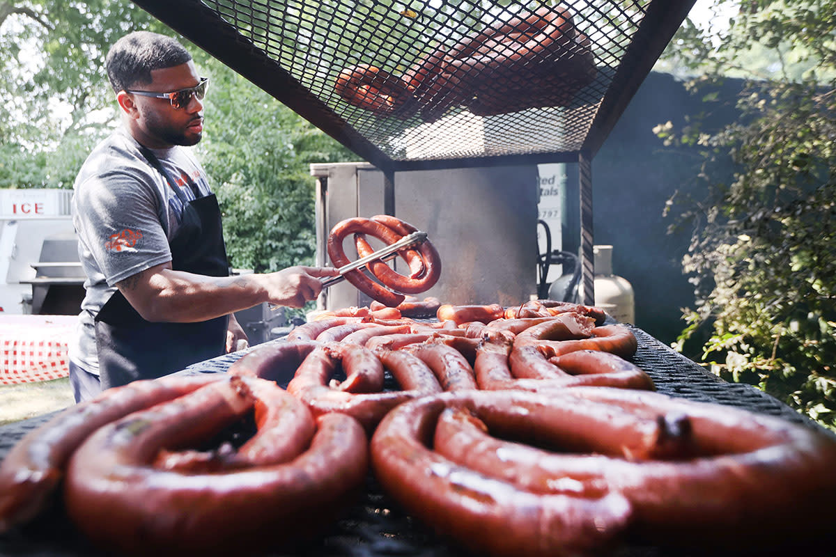 Robert Cox of Rendezvous grills sausage during the final round of the World Golf Championships FedEx-St. Jude Invitational at TPC Southwind in Memphis, Tenn. in August.