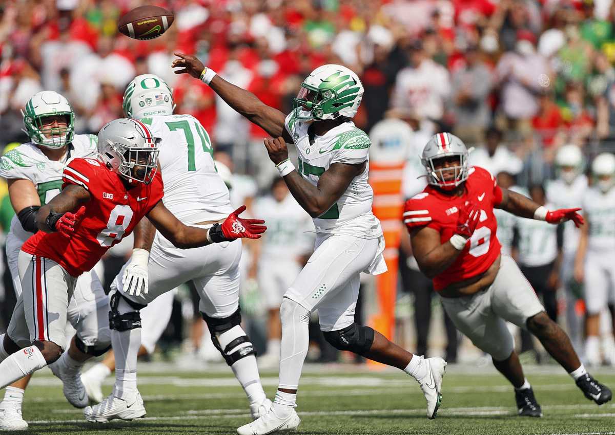 Oregon Ducks quarterback Anthony Brown (13) throws the ball against Ohio State Buckeyes defensive end Javontae Jean-Baptiste (8).