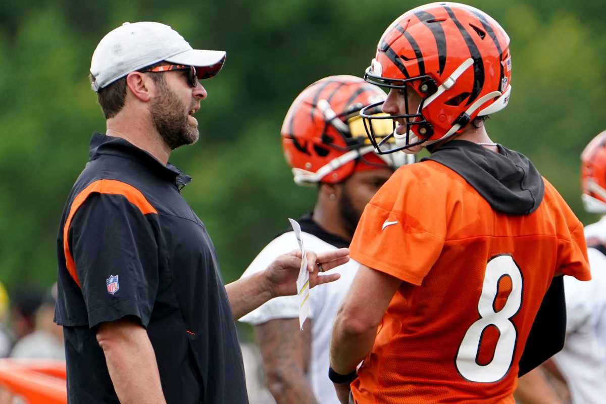 Cincinnati Bengals offensive coordinator Brian Callahan, left, talks with Cincinnati Bengals quarterback Brandon Allen (8), right, during Cincinnati Bengals training camp practice, Monday, Aug. 1, 2022, at the practice fields next to Paul Brown Stadium in Cincinnati.