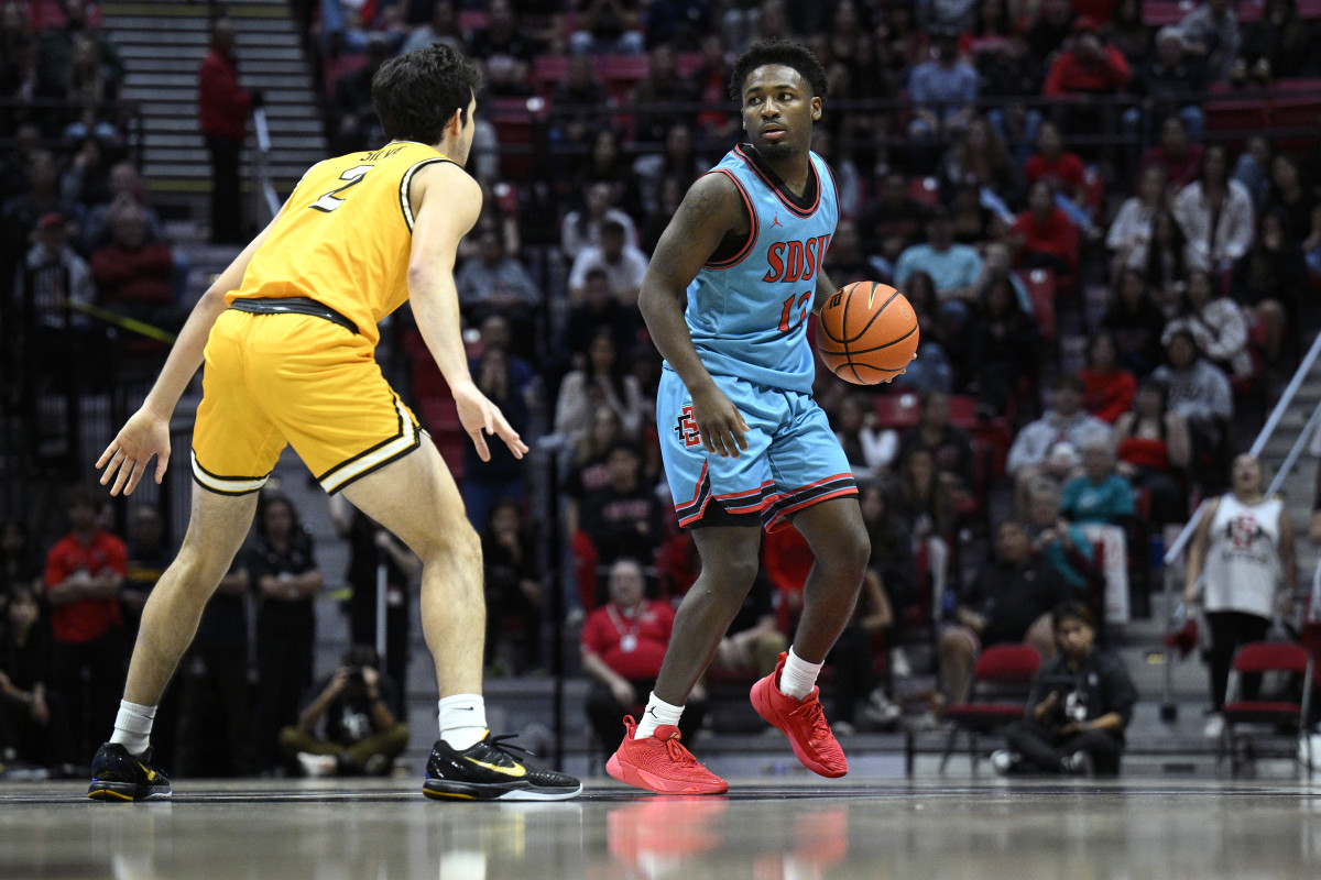 Nov 14, 2023; San Diego, California, USA; San Diego State Aztecs guard Darrion Trammell (12) dribbles while defended by Long Beach State 49ers guard Isa Silva (2) during the second half at Viejas Arena. Mandatory Credit: Orlando Ramirez-USA TODAY Sports