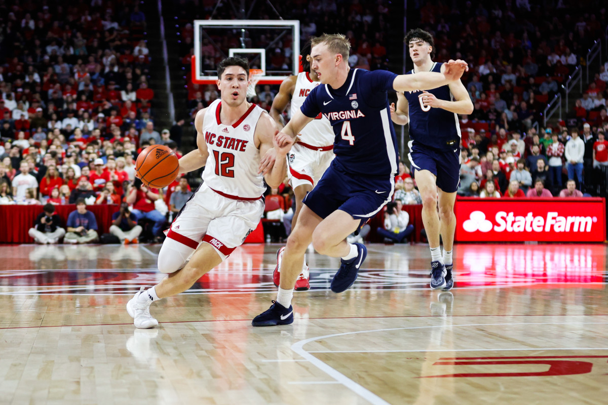 Jan 6, 2024; Raleigh, North Carolina, USA; North Carolina State Wolfpack guard Michael O'Connell (12) dribbles with the ball guarded by Virginia Cavaliers guard Andrew Rohde (4) during the first half at PNC Arena. Mandatory Credit: Jaylynn Nash-USA TODAY Sports