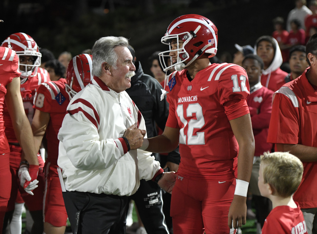 Mater Dei coach Bruce Rollinson and quarterback Elijah Brown enjoy a moment during the Monarchs' 17-7 win over St. John Bosco Friday at Santa Ana Stadium. Photo: Heston Quan. 