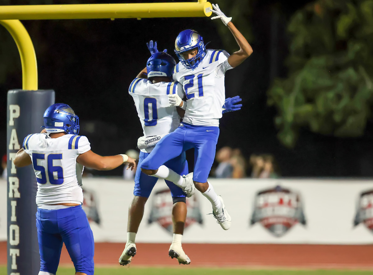 Zander Benitez (56), Skylar Lendsey (0) and Sean Embree (21) celebrate a touchdown in Friday's 34-14 win at Liberty. Photo: Joe Bergman