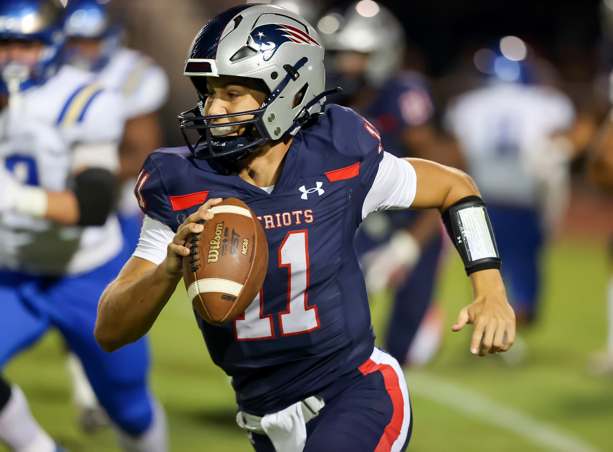 Liberty quarterback Cole O'Brien races for yardage. Photo: Joe Bergman