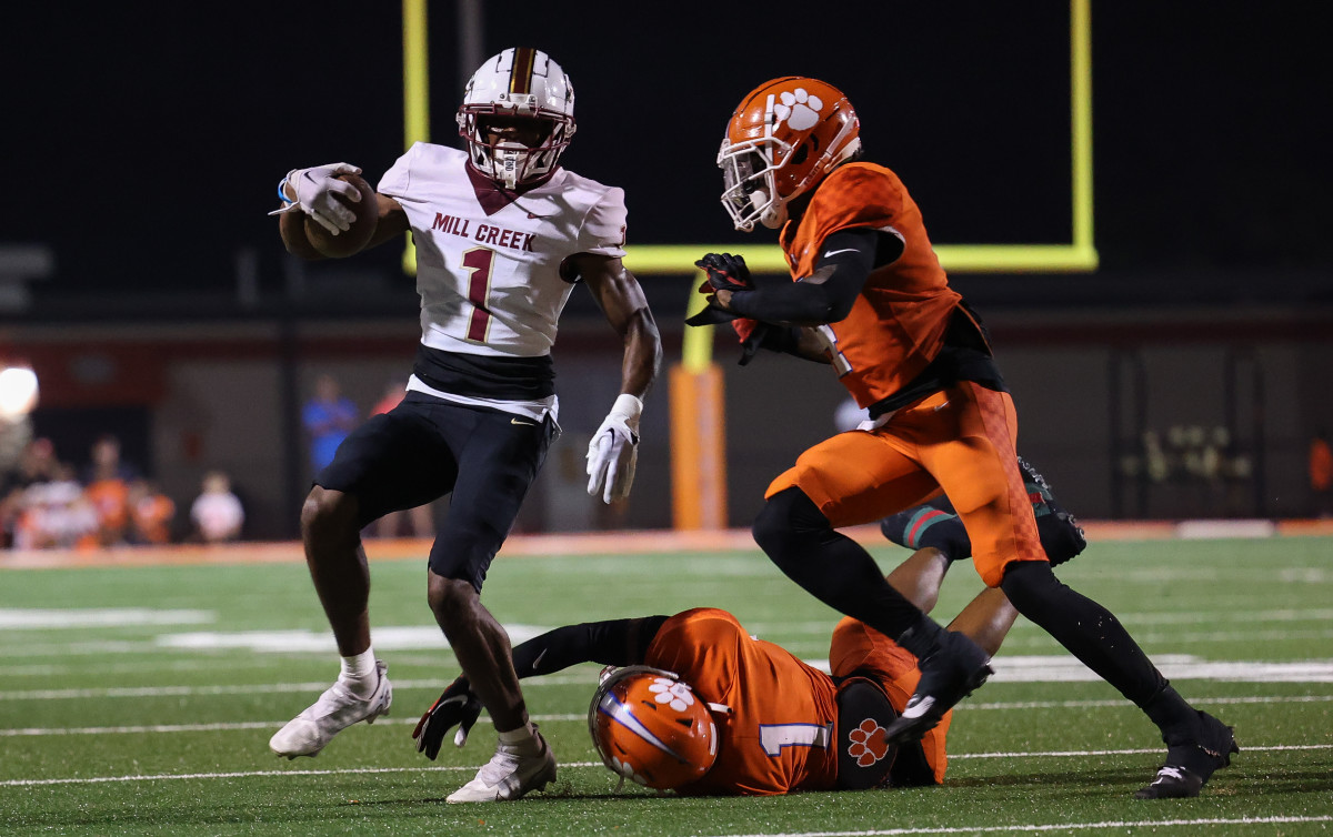 Mill Creek's Jaiden Patteson (1) batles for extra yardage