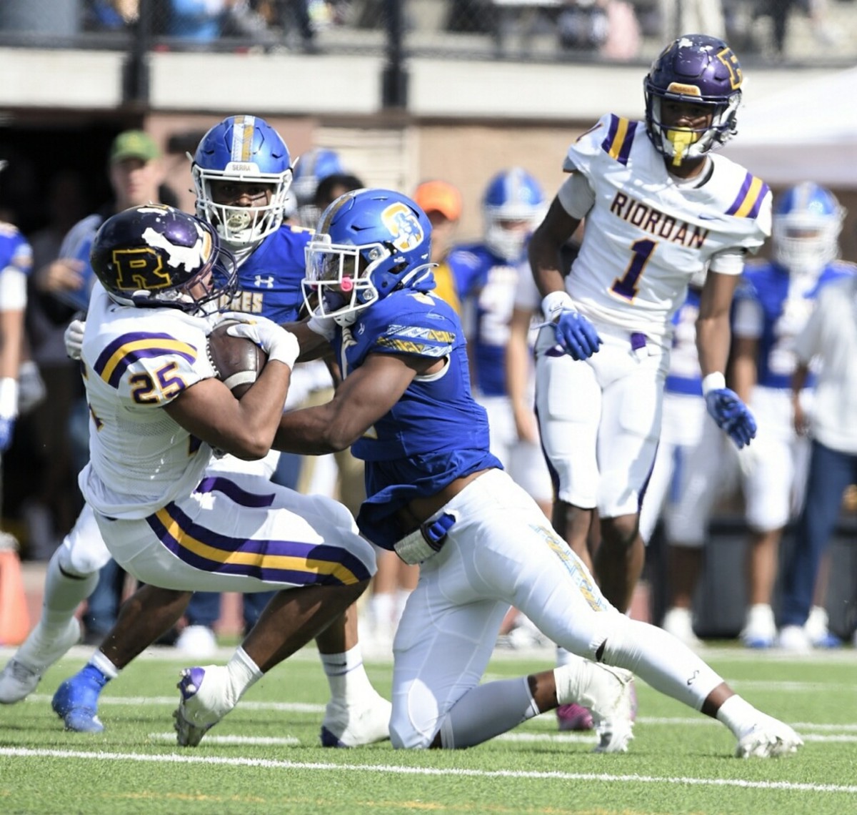 Riordan running back Charle Johnson (25) is hit hard by Jabari Mann (5).