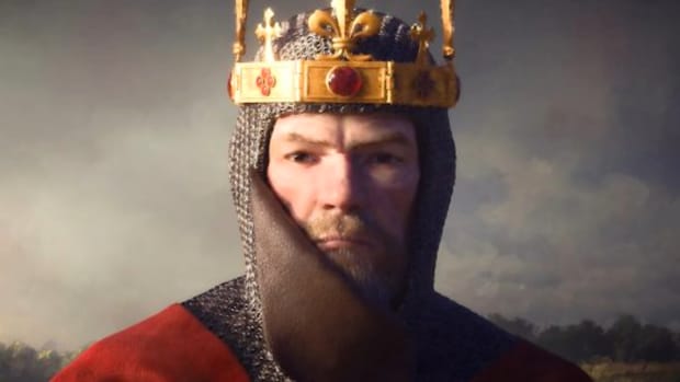 A man wearing a medieval gold crown adorned with a fleur-de-lis motif, a chain mail cap, and red armor stares into the camera