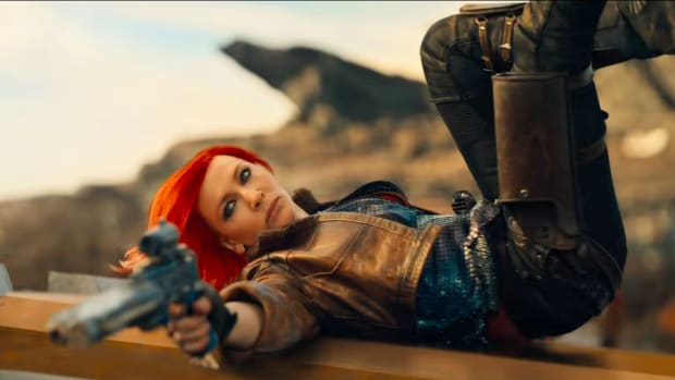 Cate Blanchett as Borderlands' Lilith, firing a pistol while rolling over a car