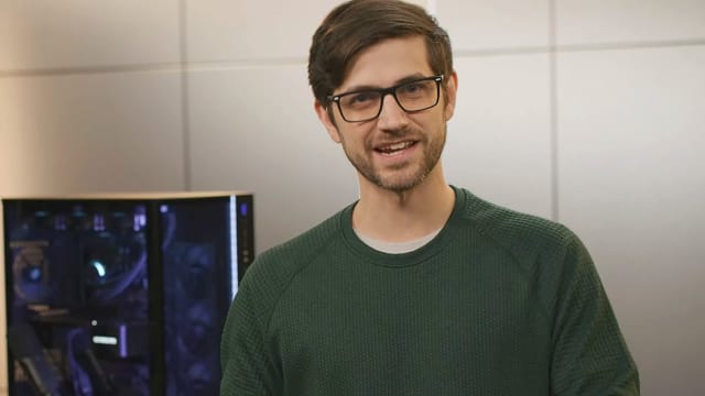 Nvidia product manager Seth Schneider is shown standing next to a high-tech gaming PC.