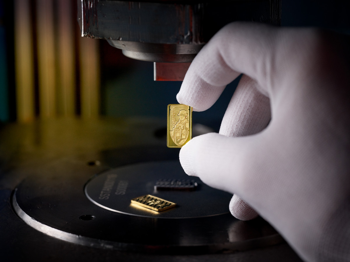 Image of a hand holding a small gold bar.