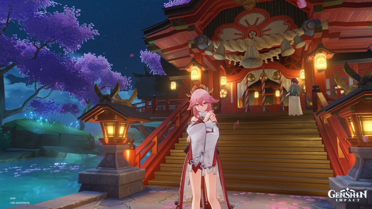 Genshin Impact's Yae Miko, standing in front of Mt Yougou shrine as lantern light softly illuminates the surrounding cherry blossom trees