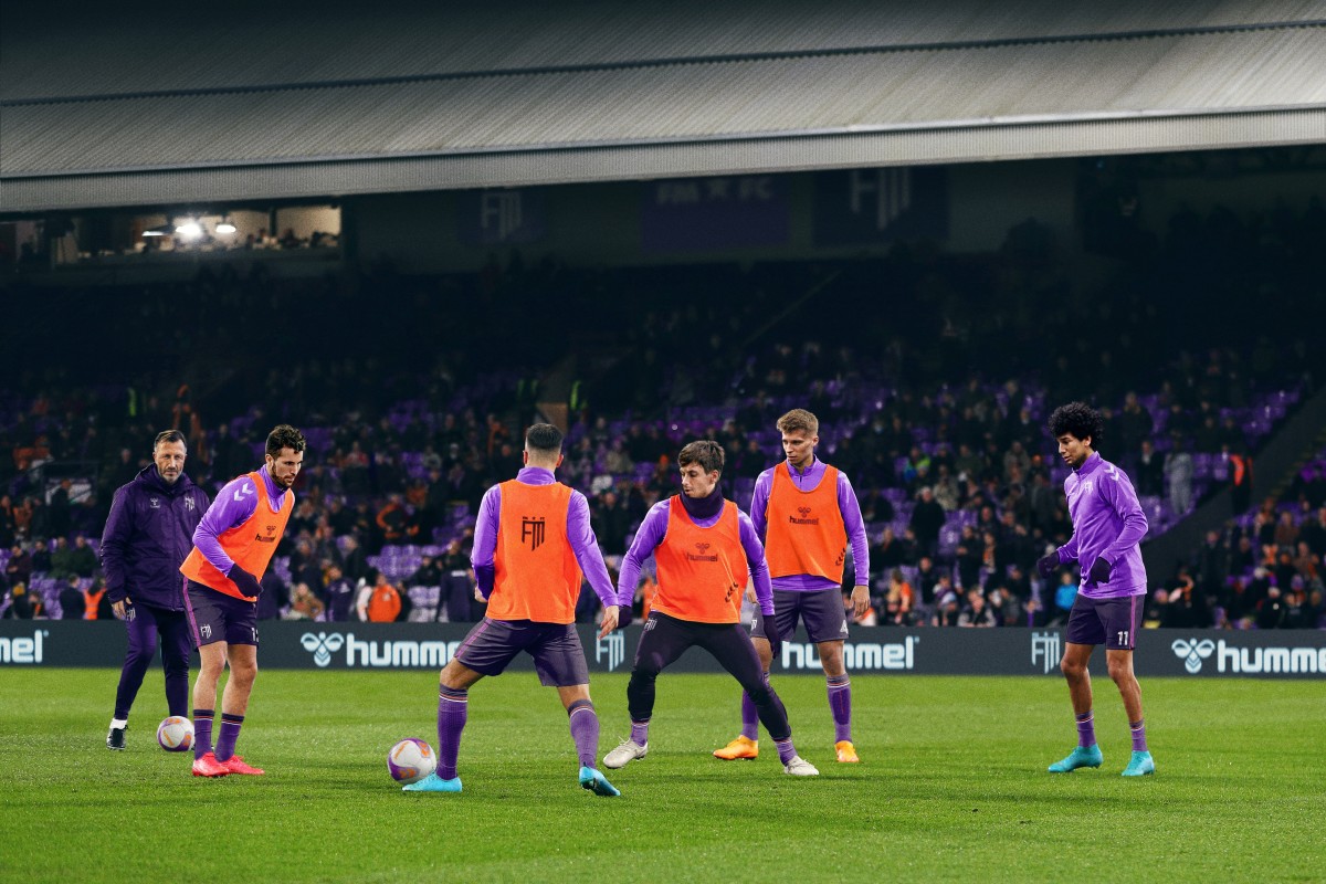 Football Manager 2024 promo shot with players practicing on the field.